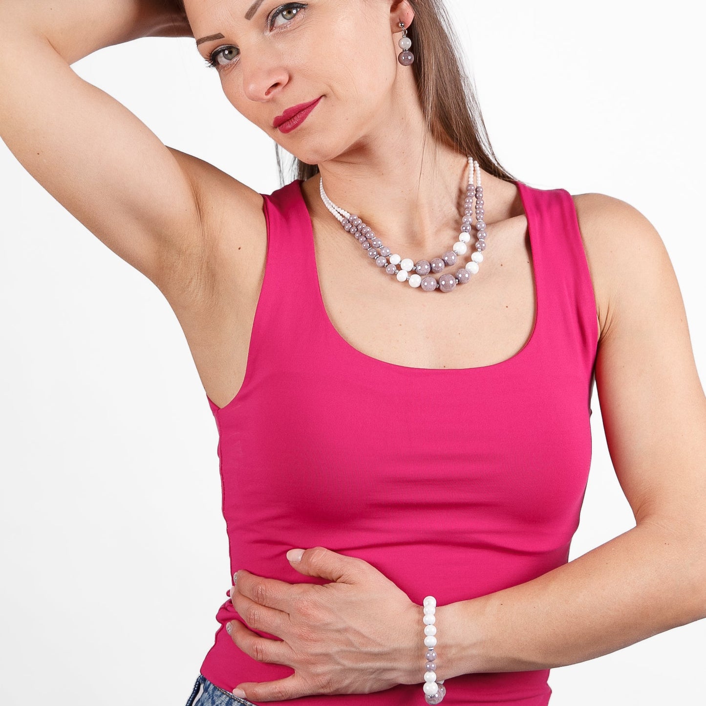Woman wearing a pink tank top with a plain background